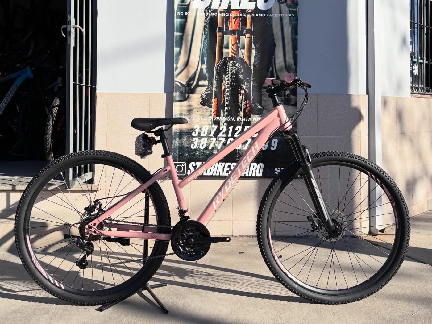 Bicicleta Rydetech 500 Lady rosa apoyada frente al local de STA BIKES